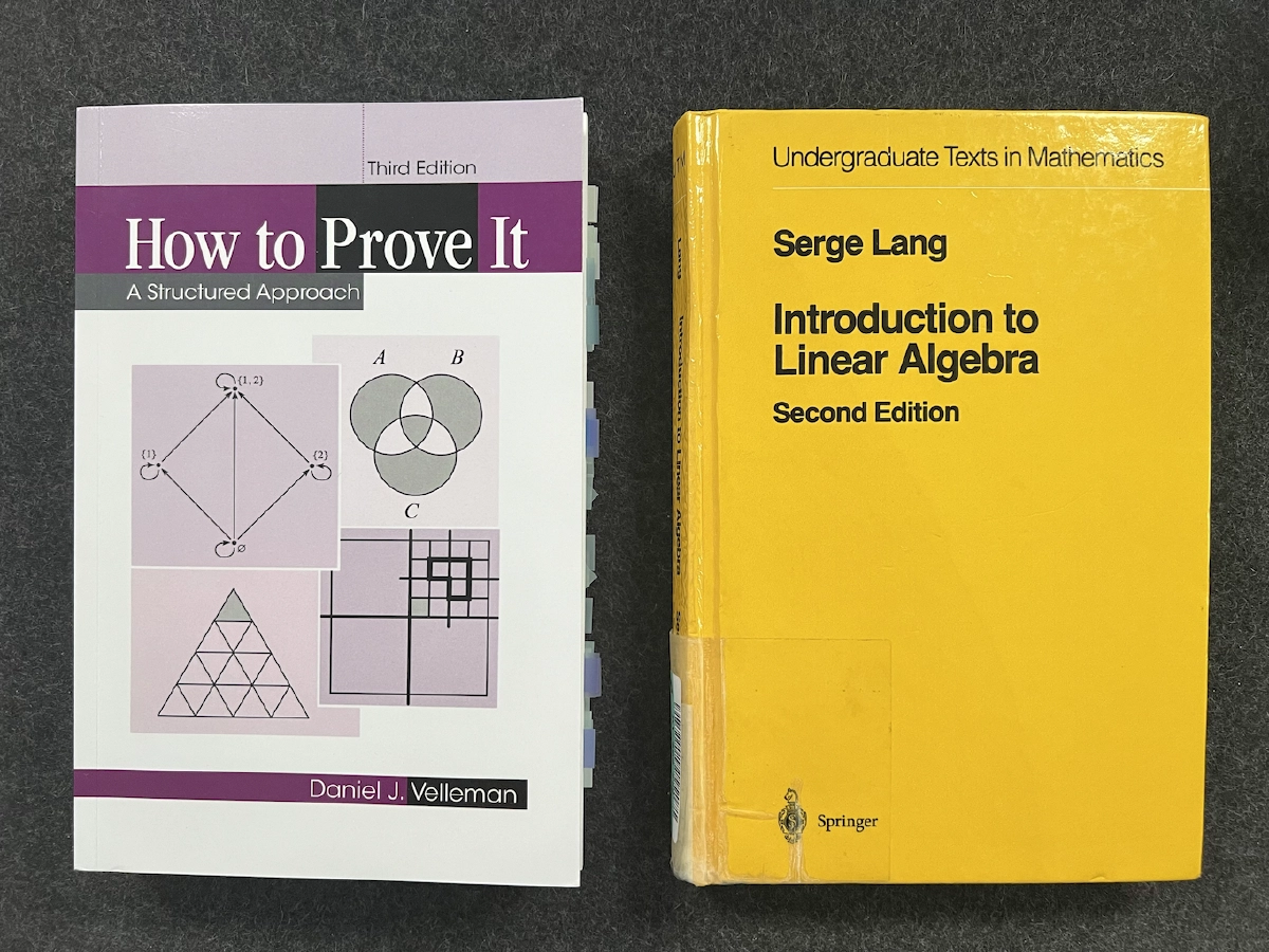The two books on my desk: How to Prove It by Velleman and Introduction to Linear Algebra by Lang